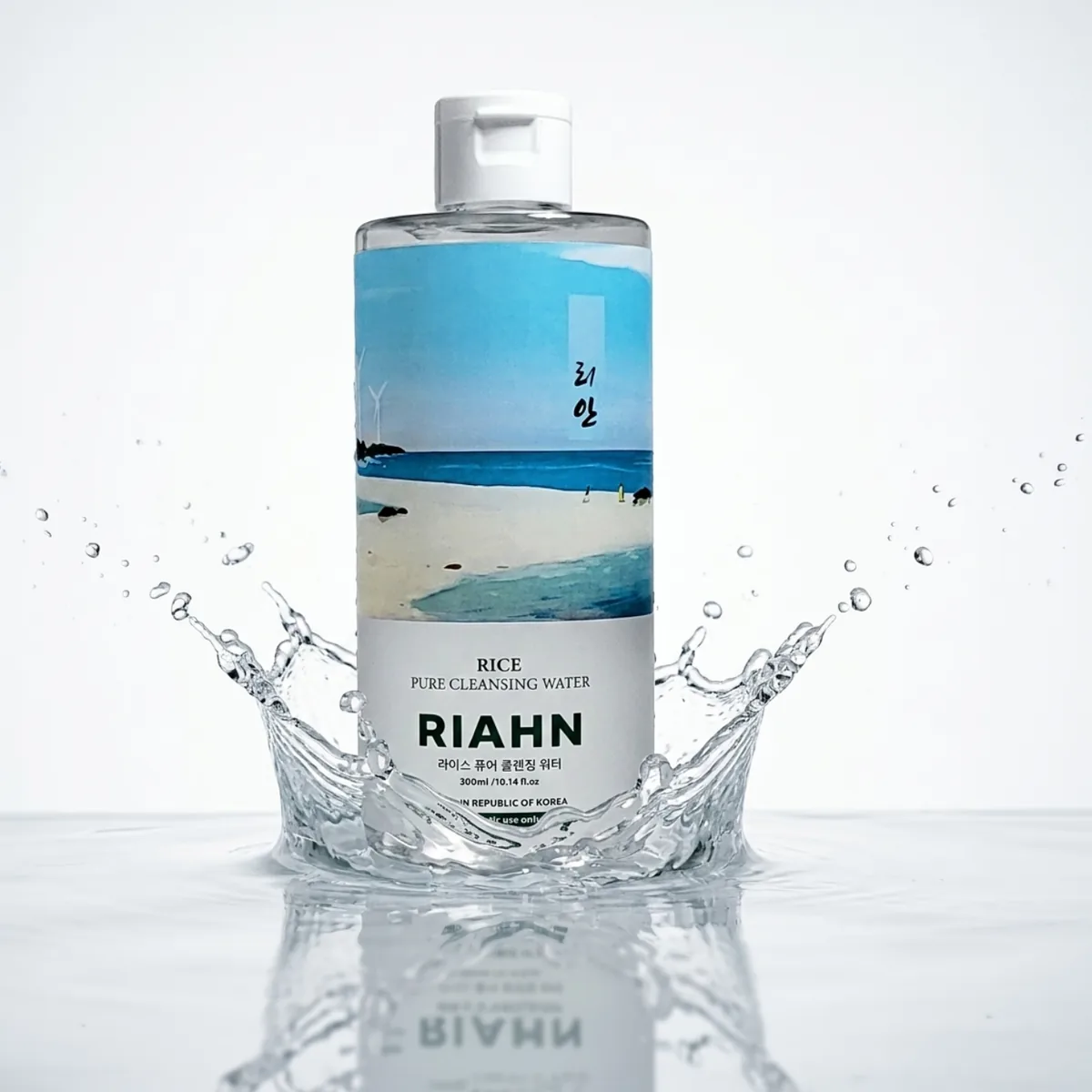 Rice Pure Cleansing Water: standing in a crown-shaped splash of clear water against a pale studio field.
